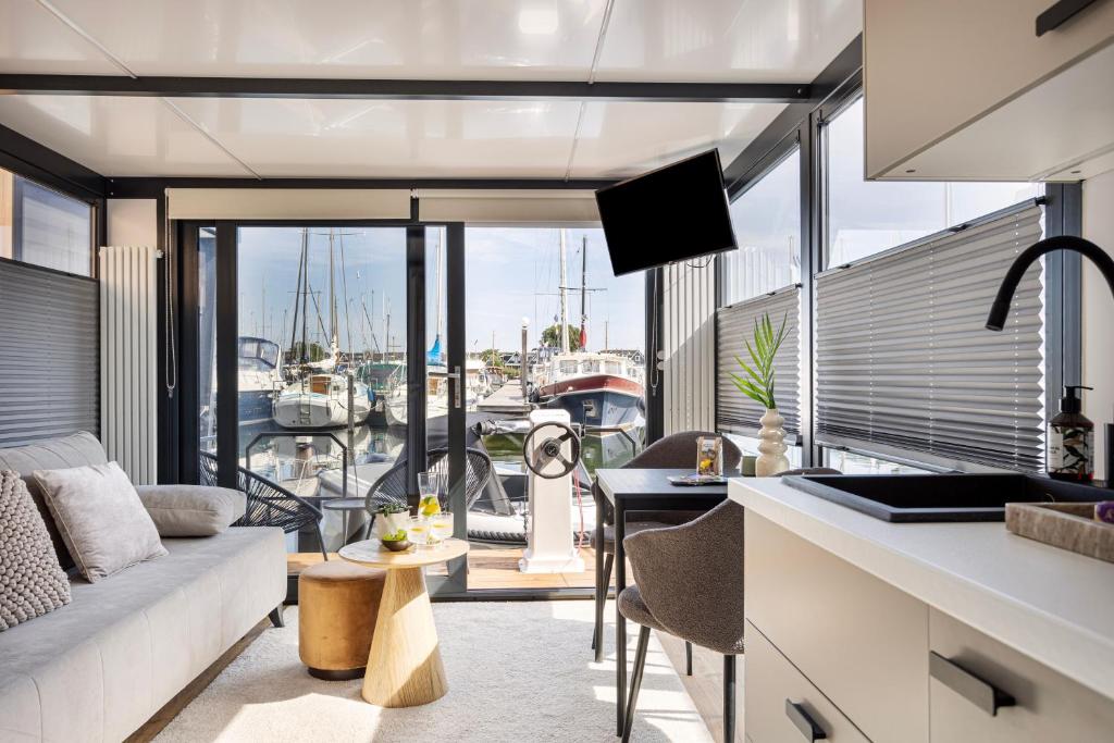泽沃德Cosy tiny houseboats near beach and restaurants的厨房以及享有码头景致的客厅。