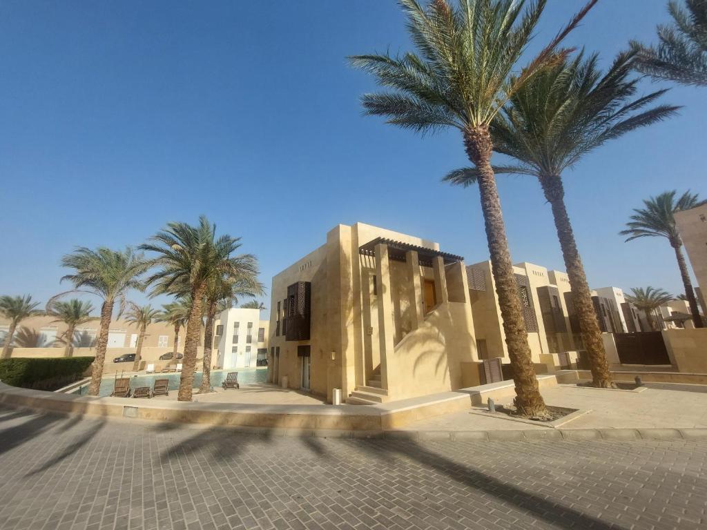 赫尔格达Nayah Stays, Ground terraces Studio的街道前方有棕榈树的建筑
