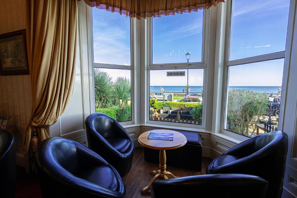 兰迪德诺Can-Y-Bae Hotel的客房设有椅子和海景窗户。
