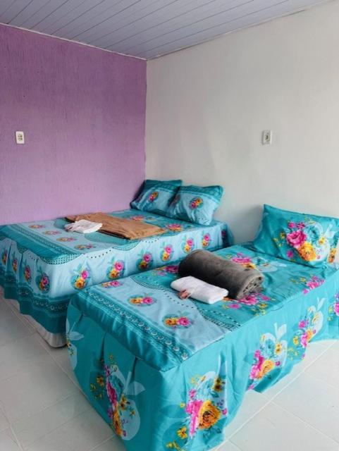 贝伦Hostel das Flores的一间卧室配有一张床和一张带蓝色床单的单人床。