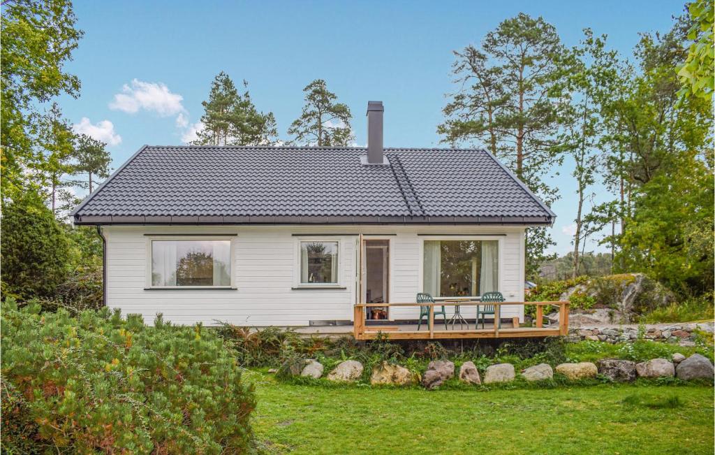 桑讷菲尤尔Amazing Home In Sandefjord With Wifi的一座小白色房子,在院子里设有甲板