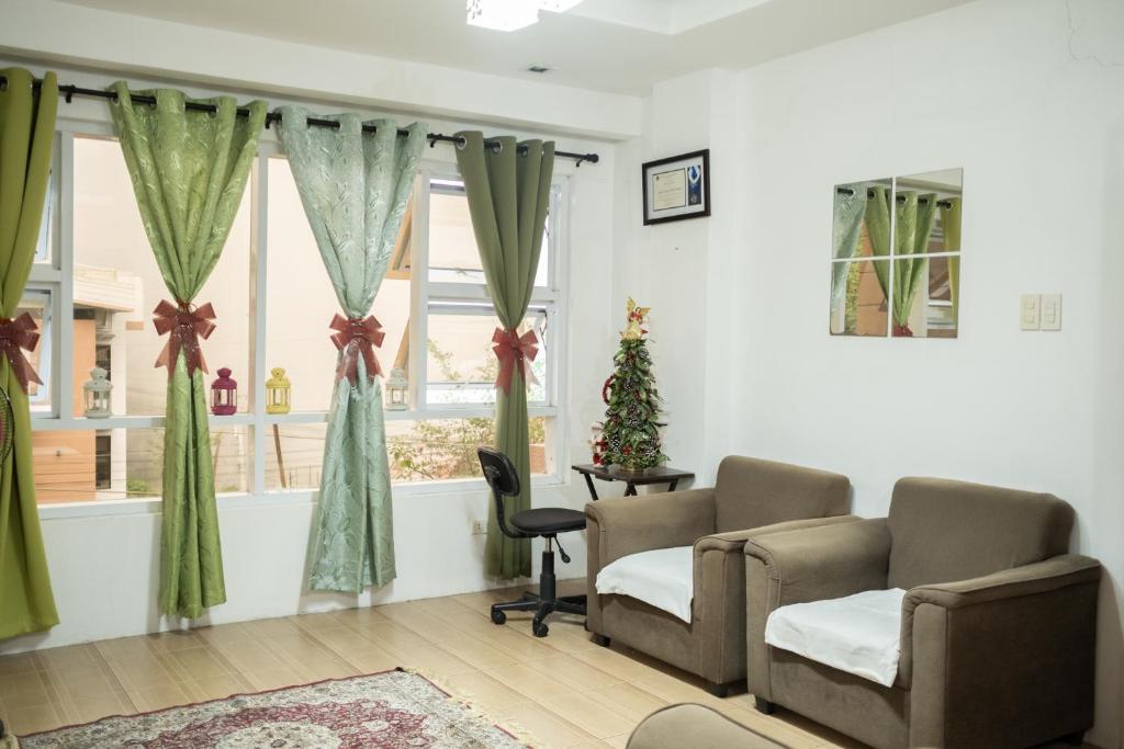 碧瑶The Greens Home & Garden - ENTIRE 3RD FLOOR的一间等待室,配有两把椅子和一棵圣诞树