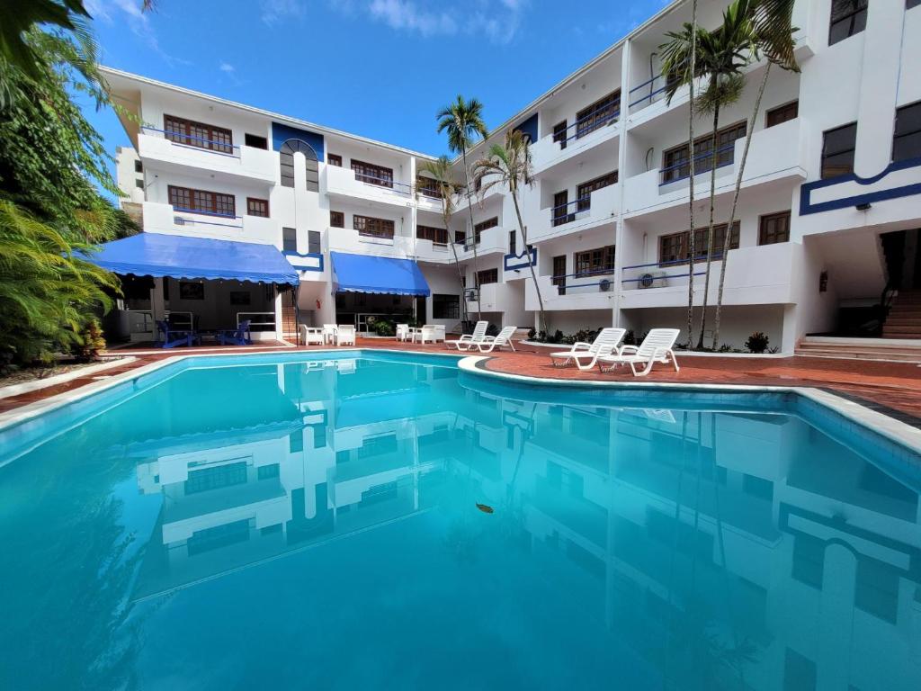 博卡奇卡Calypso Beach Hotel by The Urbn House Santo Domingo Airport的大楼前的游泳池