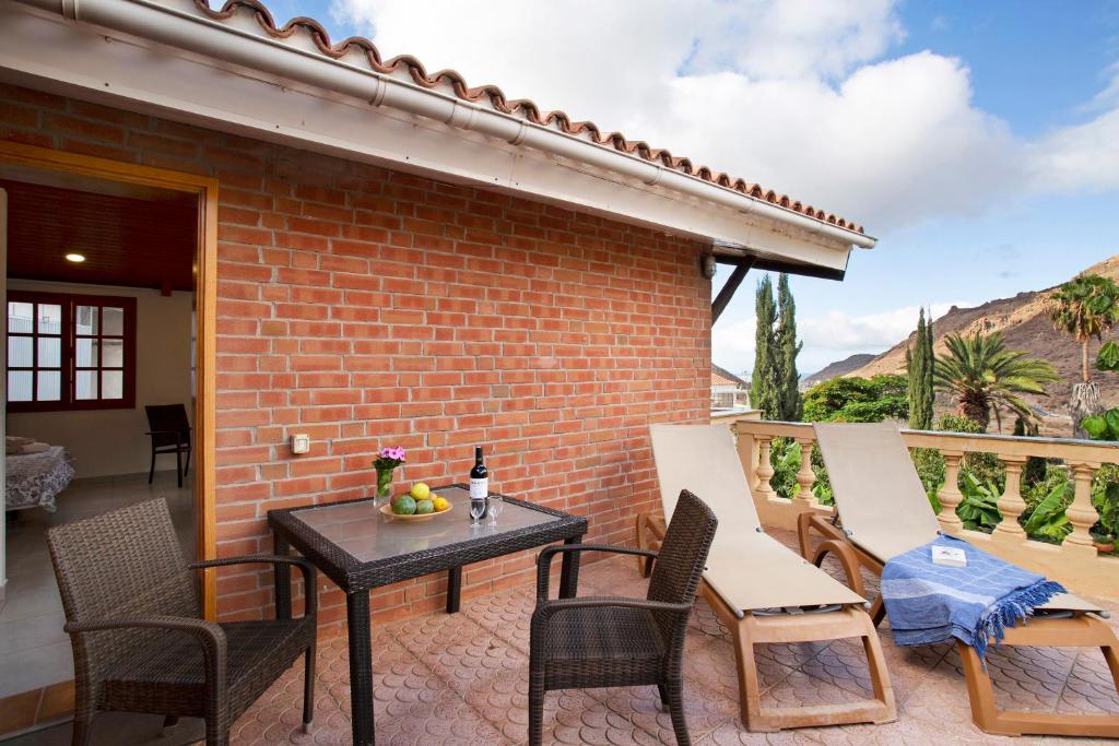 莫甘Paraiso del Molinero Alto的一个带桌椅和砖墙的庭院