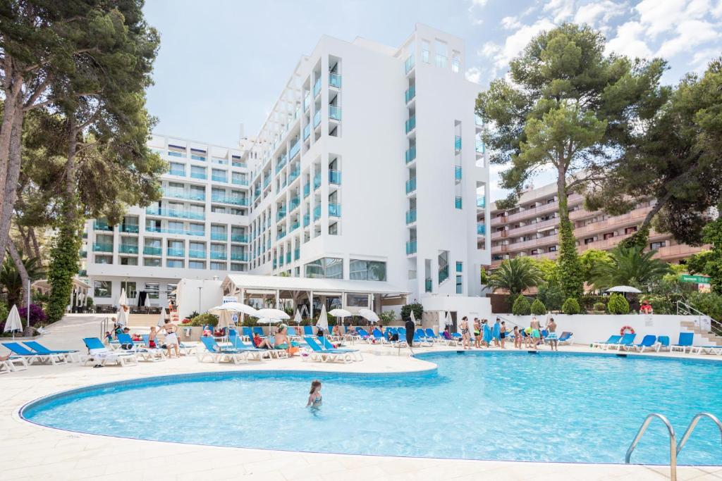 萨洛贝斯特梅迪特拉内奥 酒店的酒店游泳池的背景是一座大型建筑