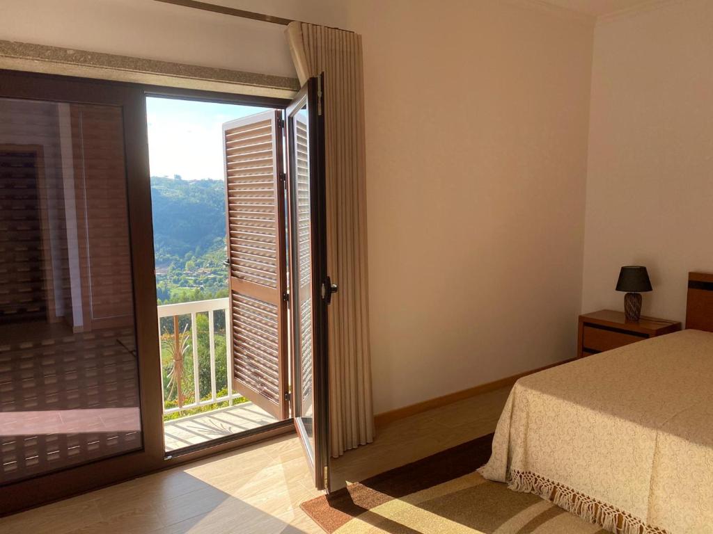 辛方伊什Quinta da Travessa的一间卧室设有一张床和一个美景窗户。