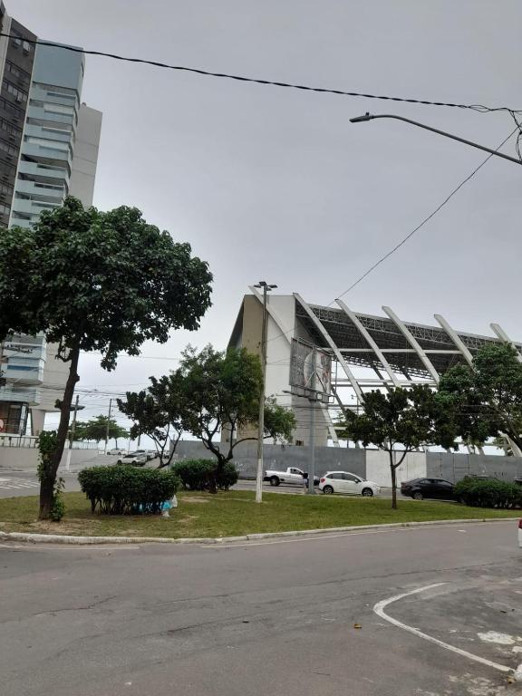 维拉维尔哈Suíte Itaipu Mar的街道前方树木繁茂的大建筑