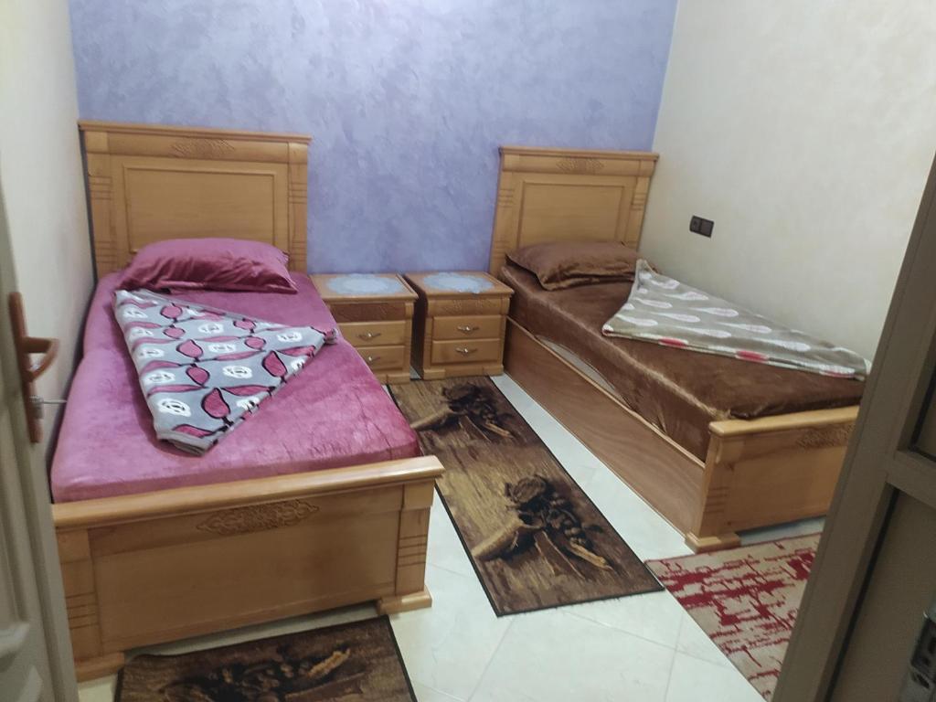 坦坦شقق فندقية بن خليل /hôtel appartements Bin khlil的紫色墙壁客房的两张单人床