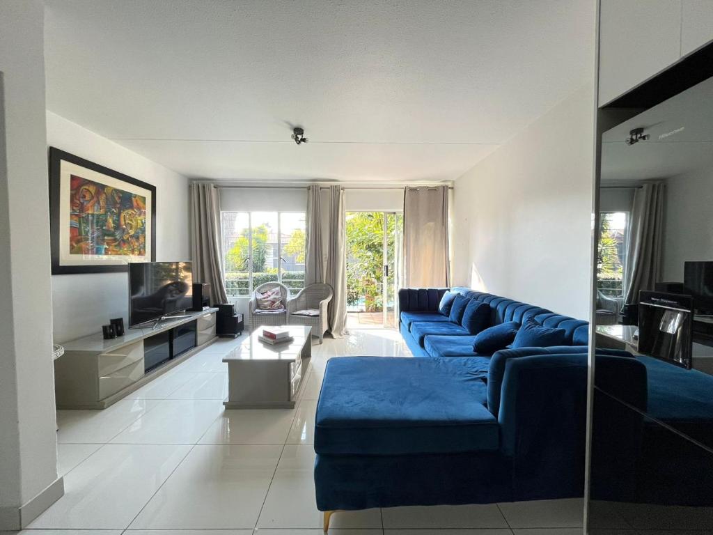 鲁德普特Royal Retreat的客厅配有蓝色的沙发和电视