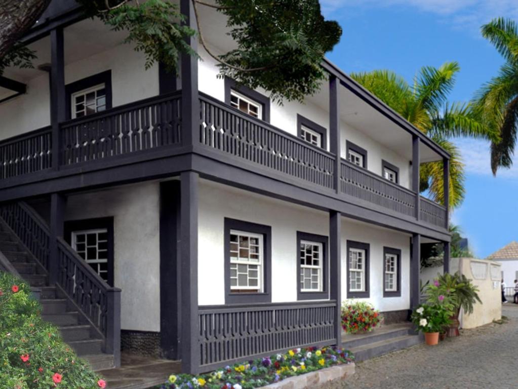 Vila Nova SintraHotel POUSADA Brava的白色和黑色的房子设有阳台