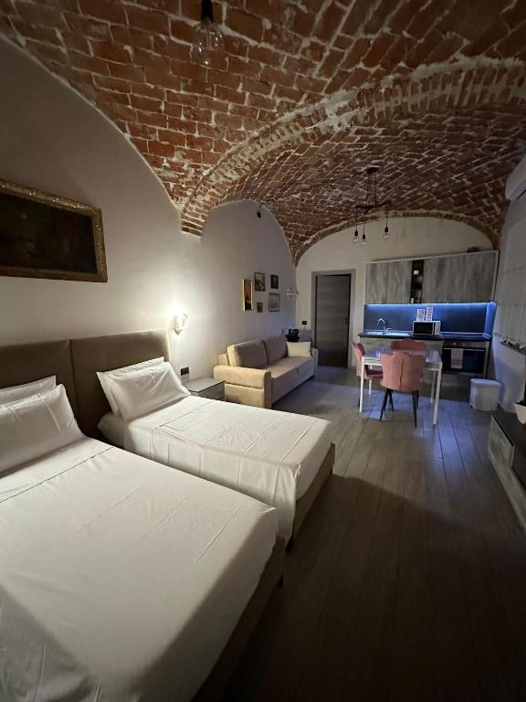 卡萨莱蒙费拉托Residenza Zotaj Small appartament的一间带两张床的卧室和一间带沙发的客厅