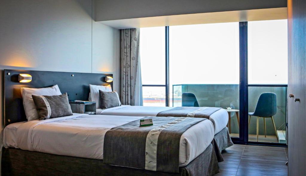 安托法加斯塔EcoApart Antofagasta的酒店客房设有两张床和大窗户。