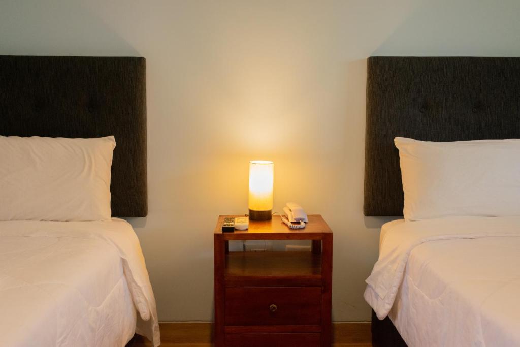 SauceHotel Laguna Azul的一间设有两张床的房间和床头灯