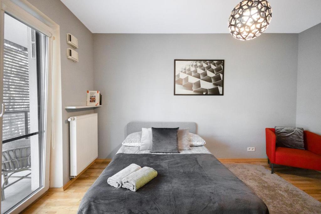 华沙ClickTheFlat Artistic Estate Apartment的一间卧室配有一张床和一张红色椅子