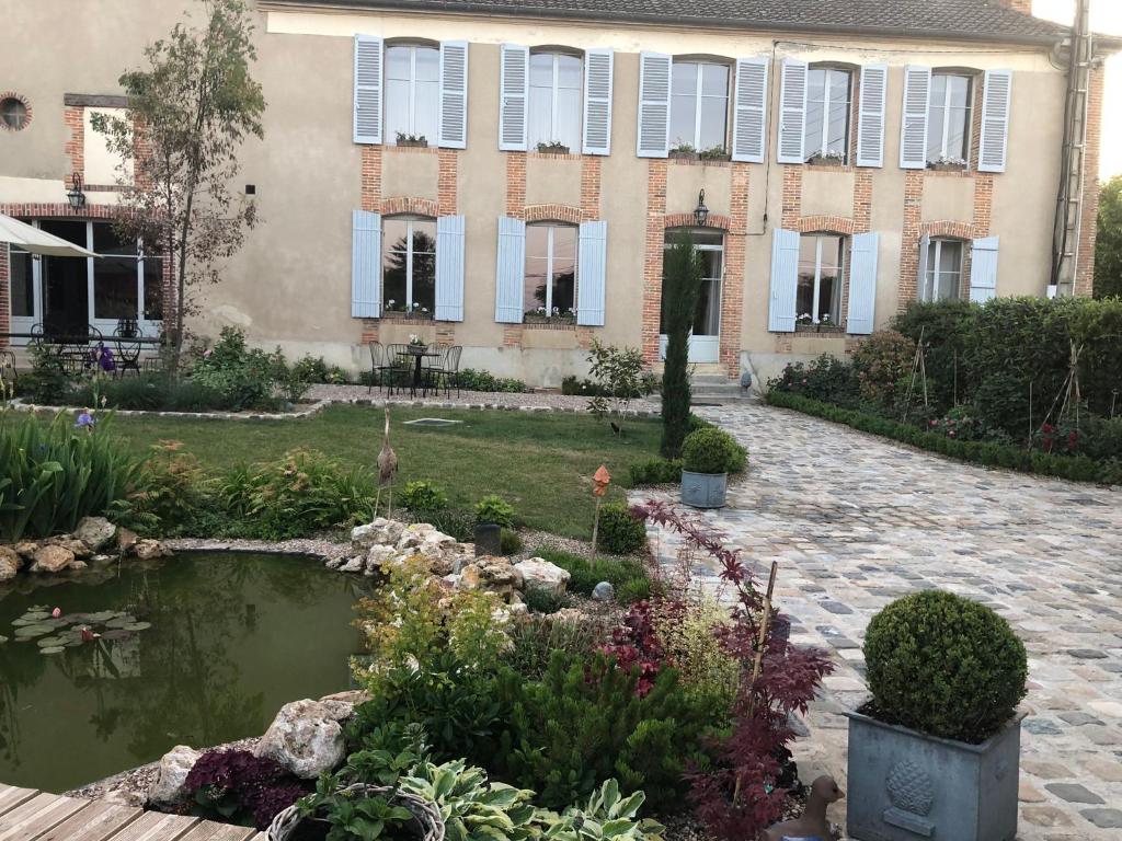 维奈La Demeure d'Agapanthe的花园前带池塘的房子