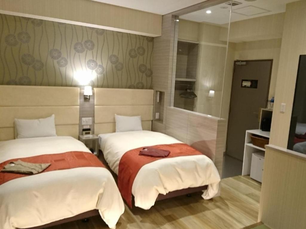 千岁QUEEN'S HOTEL CHITOSE - Vacation STAY 67739v的酒店客房,设有两张床和镜子