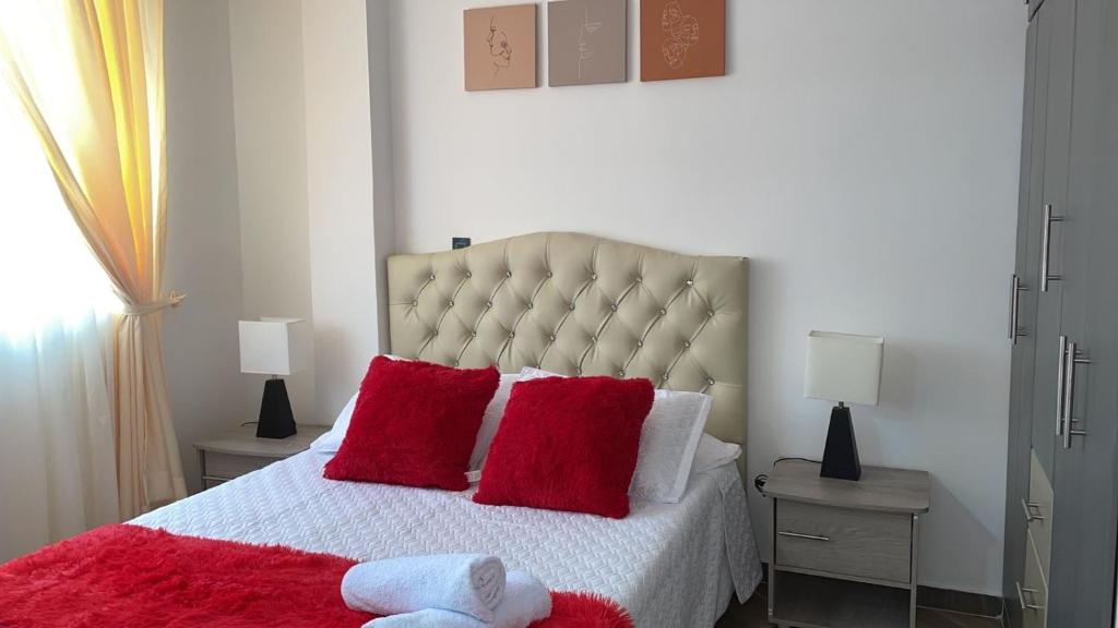 圣罗莎德卡瓦尔Moderno apto familiar piso 2的一间卧室配有一张带红色枕头的大床