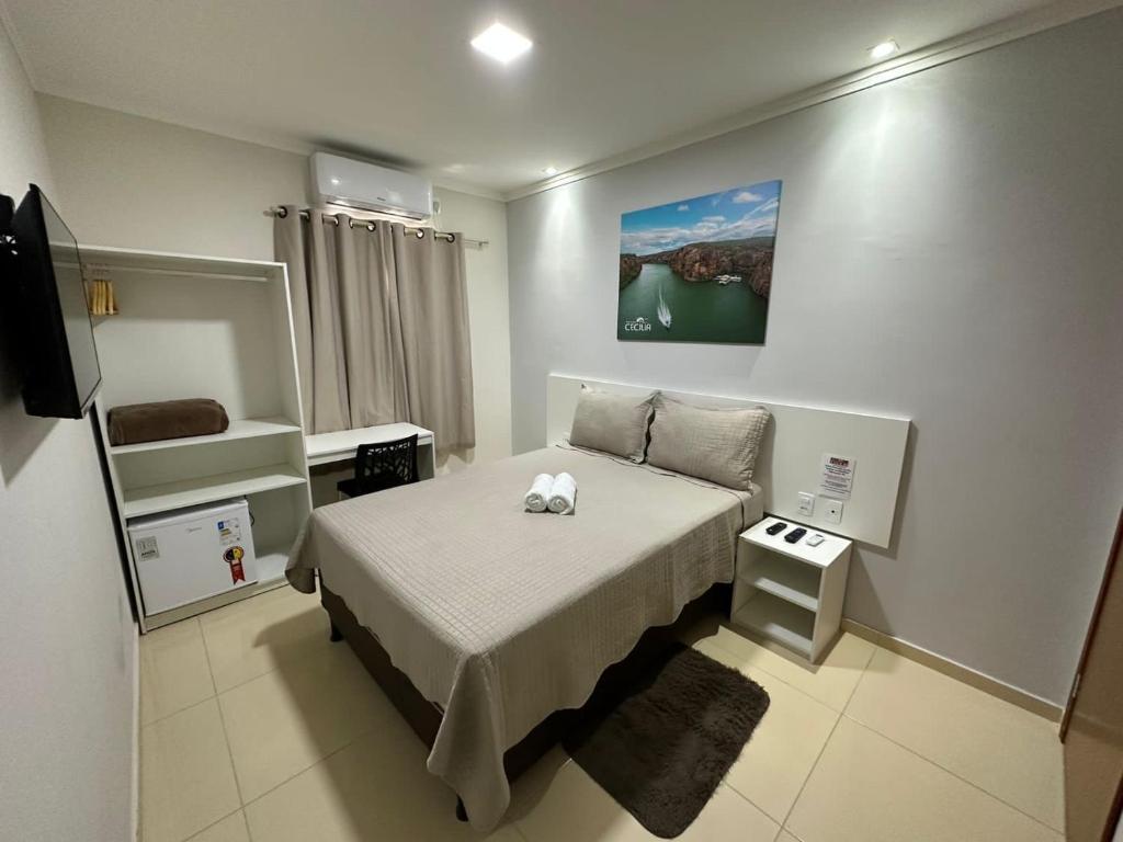 卡宁德圣弗朗西斯科POUSADA CECILIA的一间带床和电视的小卧室
