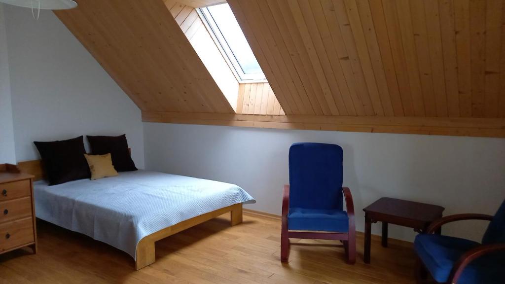 克拉科夫U Janciów的卧室配有床、椅子和窗户。