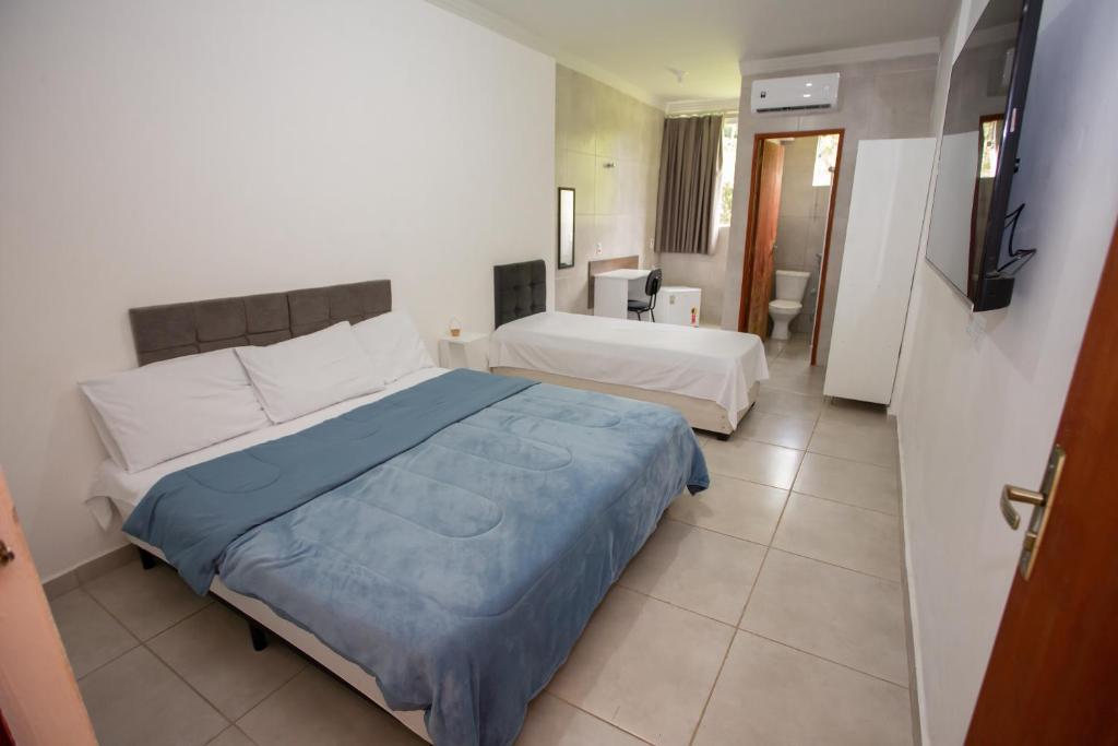 阿拉沙Ribeiro Suit's Hotel的酒店客房设有两张床和电视。