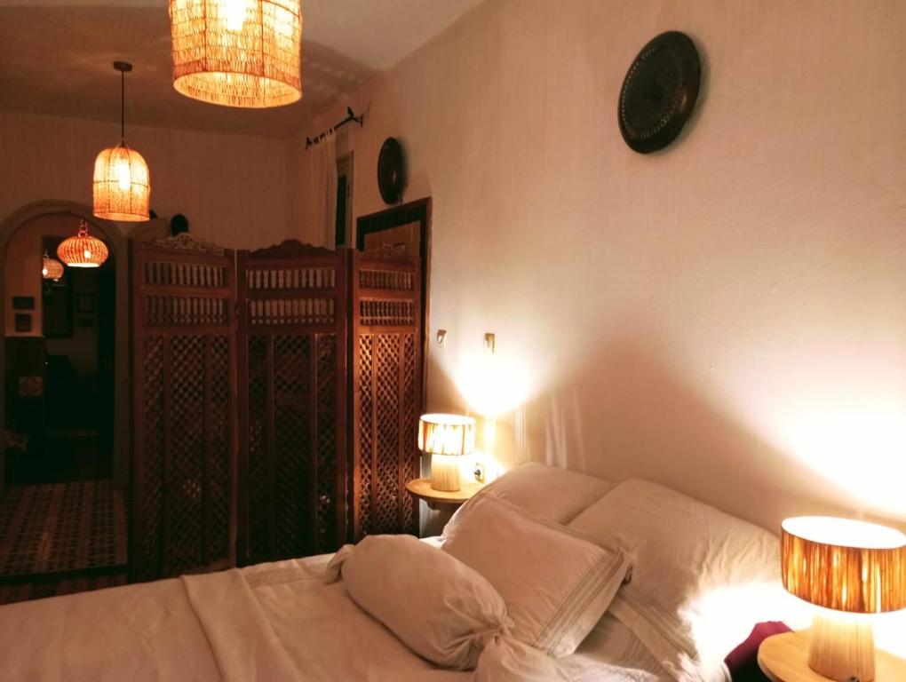 舍夫沙万Dar SBAA的一间卧室配有一张带两盏灯和两张桌子的床。
