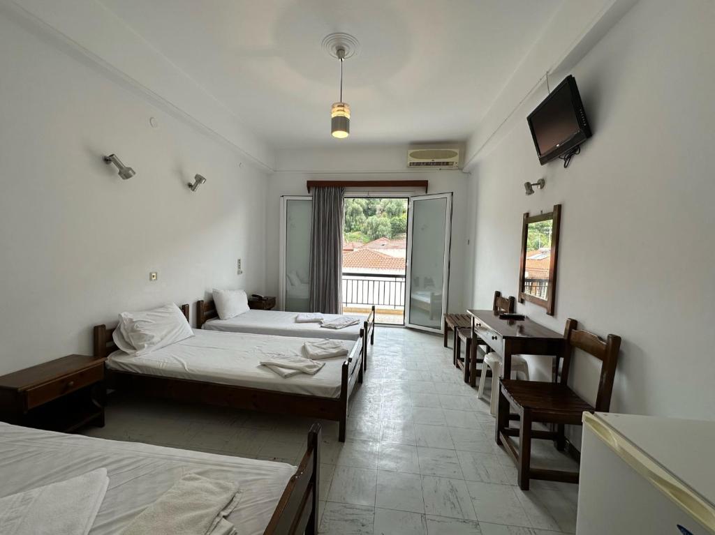 帕尔加嘉里尼酒店的客房设有三张床、一张桌子和一台电视。