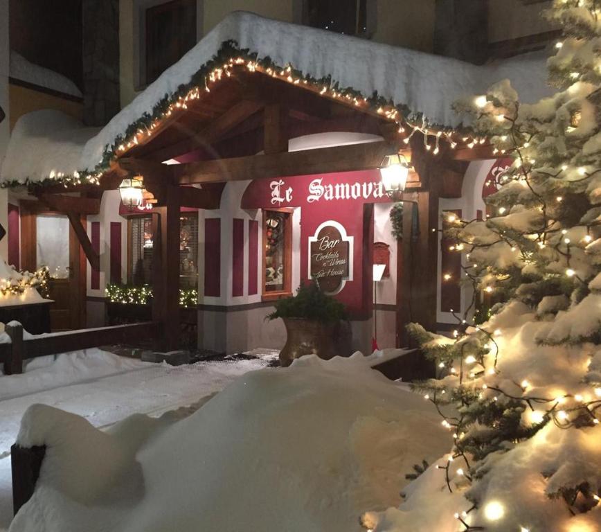 布勒伊-切尔维尼亚萨莫瓦宾馆的一座有雪盖的建筑,前面有一颗圣诞树