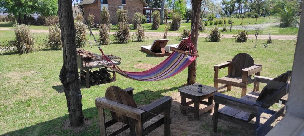 派桑杜Retiro San Francisco 2 hasta 6 huespedes -Pais Uruguay的公园内的吊床,配有椅子和桌子