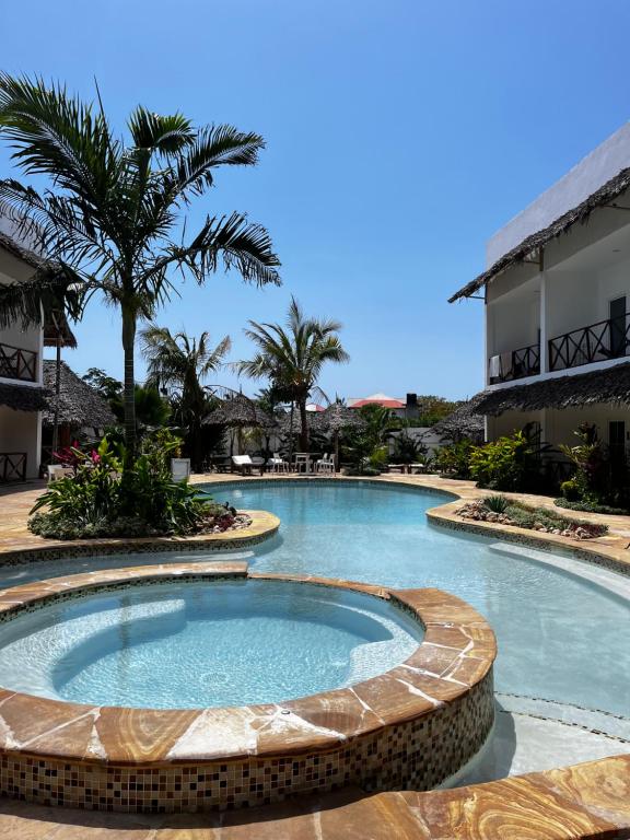 南威Kibanda Lodge and Beach Club的棕榈树度假村内的游泳池