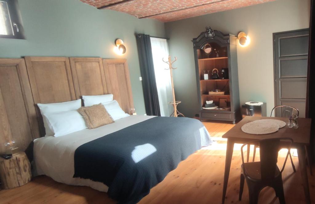 Coeur de ferme en Pévèle的一间卧室配有一张床、一张桌子和一面镜子