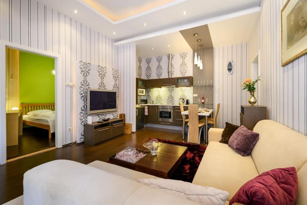 布达佩斯Chrysoprase Apartment的一间带白色沙发的客厅和一间厨房