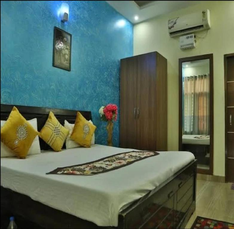 齐拉克普尔Hotel Sunkriti Resort的一间卧室配有一张带黄色枕头的大床