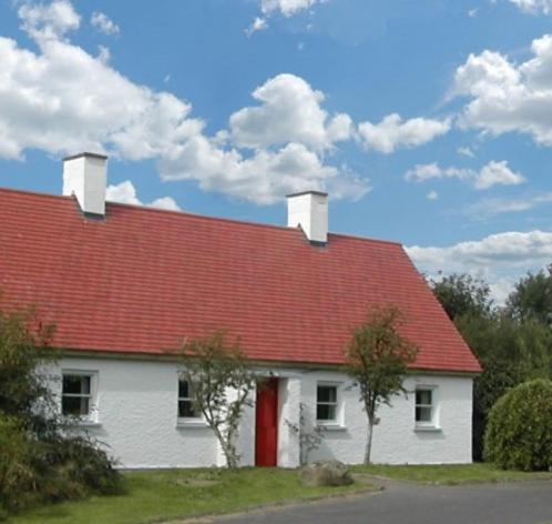 朗福德Longford Holiday Red Rose Self Catering Cottage的白色房子,有红色屋顶