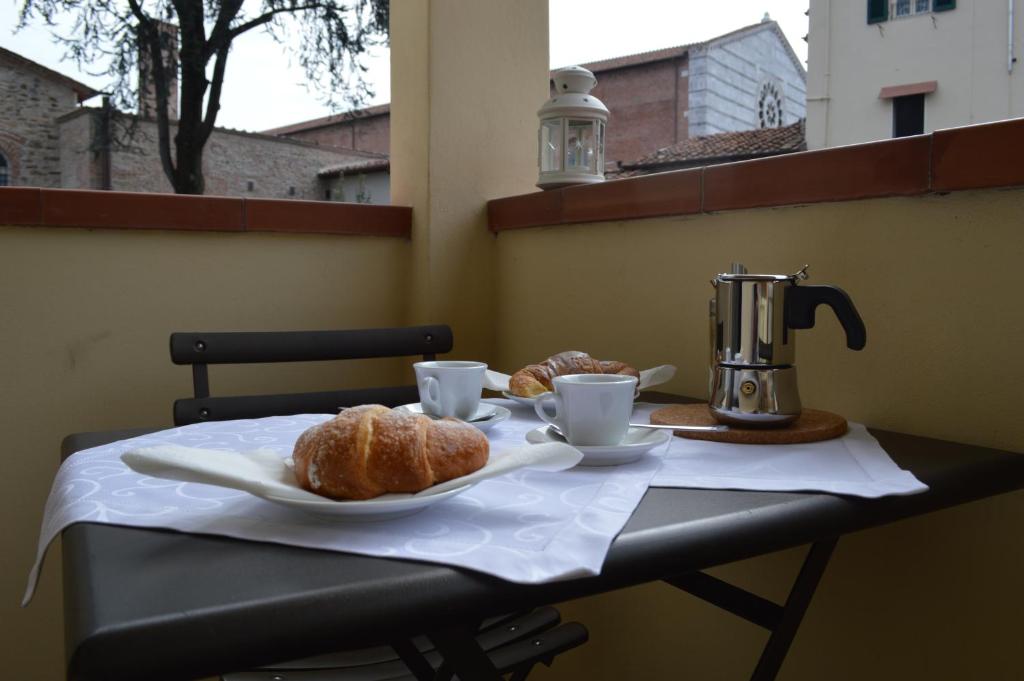卢卡拉卡萨帝拉克莱公寓的一张桌子,上面放着两杯咖啡和羊角面包