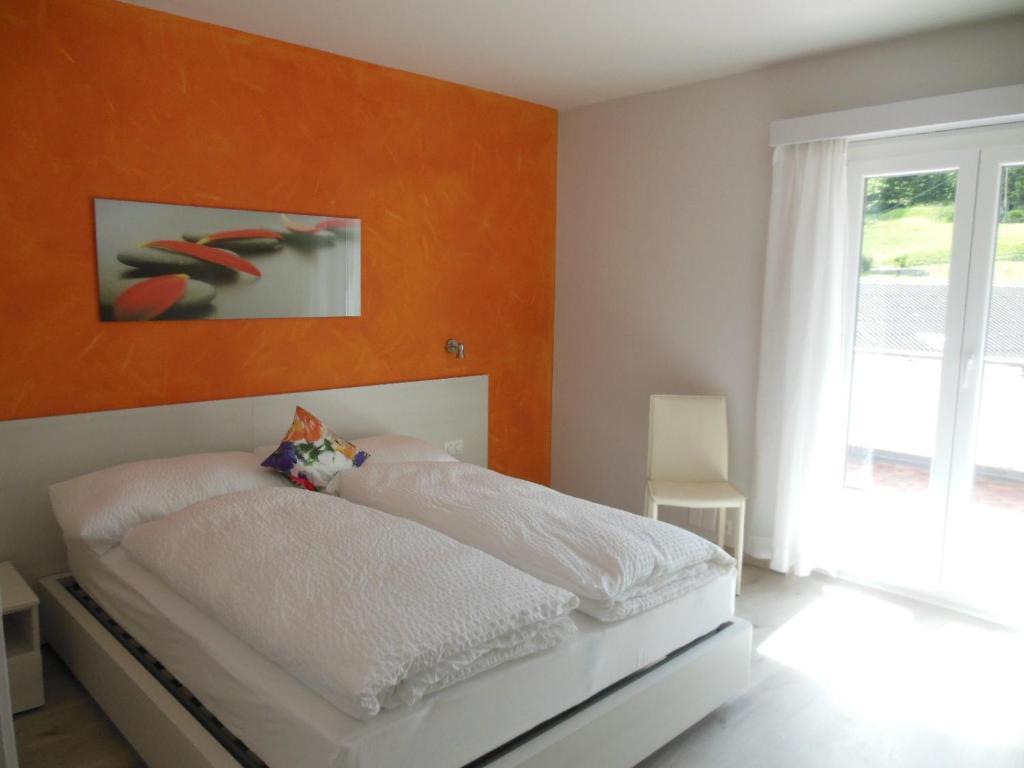 Prato特恩西亚住宿加早餐旅馆的一间卧室配有一张白色的床和橙色的墙壁