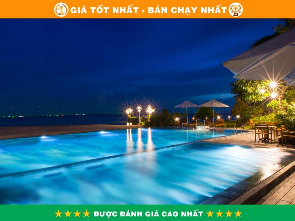 富国Chez Carole Beach Resort Phu Quoc的夜间游泳池,灯光照亮