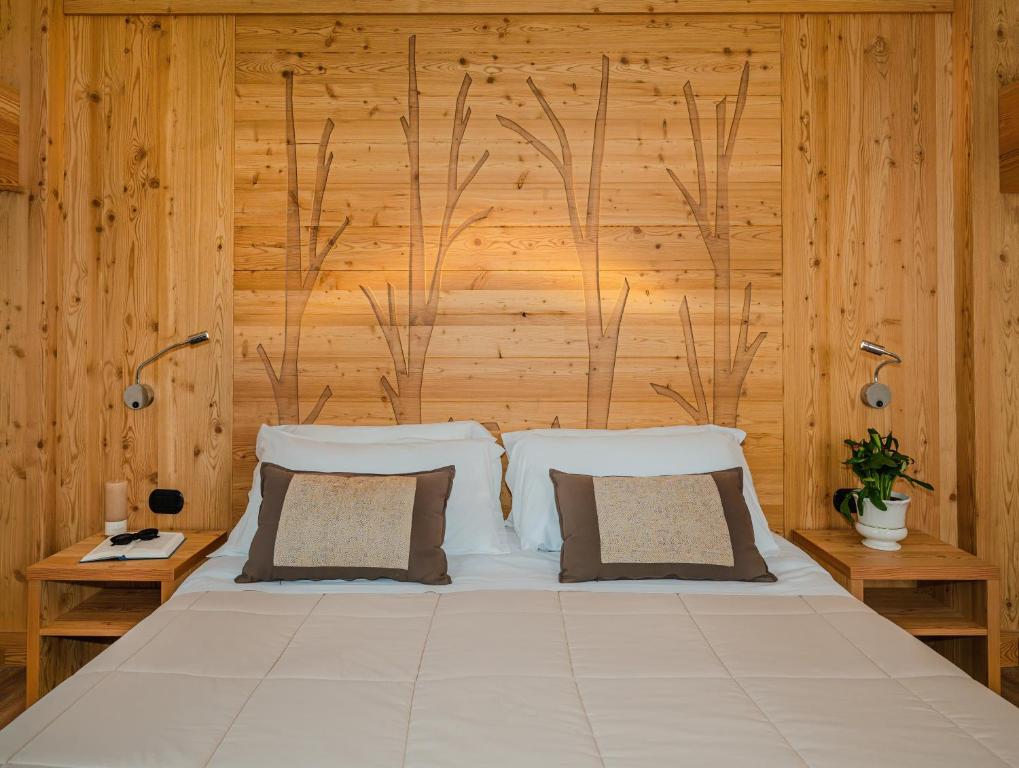 奥温多利Ovindoli Park Hotel & SPA的一间卧室配有一张带木墙的大床
