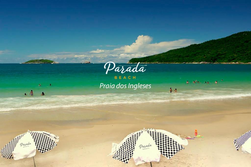 弗洛里亚诺波利斯Parada Beach Beira-Mar e Aptos 70m do Mar的海滩上有遮阳伞和水中的人