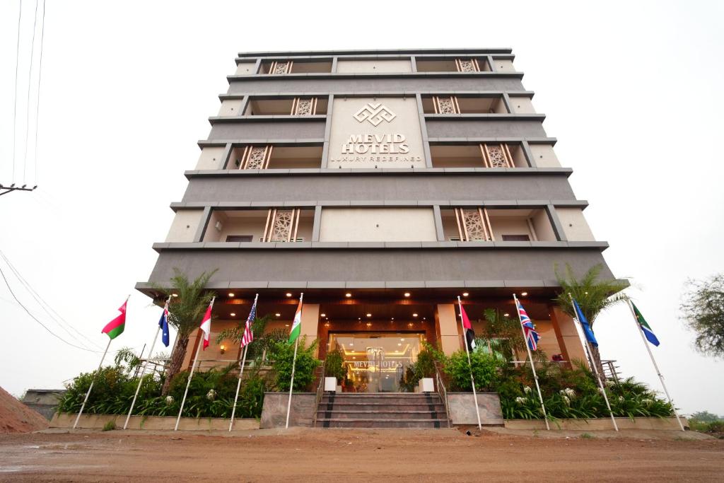 海得拉巴Mevid Hotels的前面有旗帜的建筑