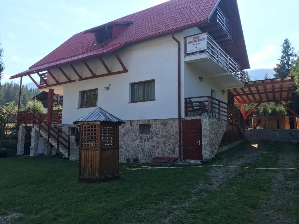 阿列谢尼Casa dintre Brazi的一座大型白色房屋,设有红色屋顶