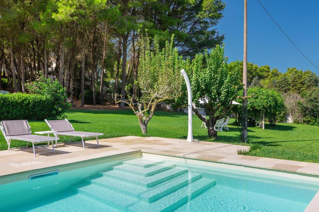 加利波利蒂莫公寓旅馆的庭院旁带两把椅子的游泳池