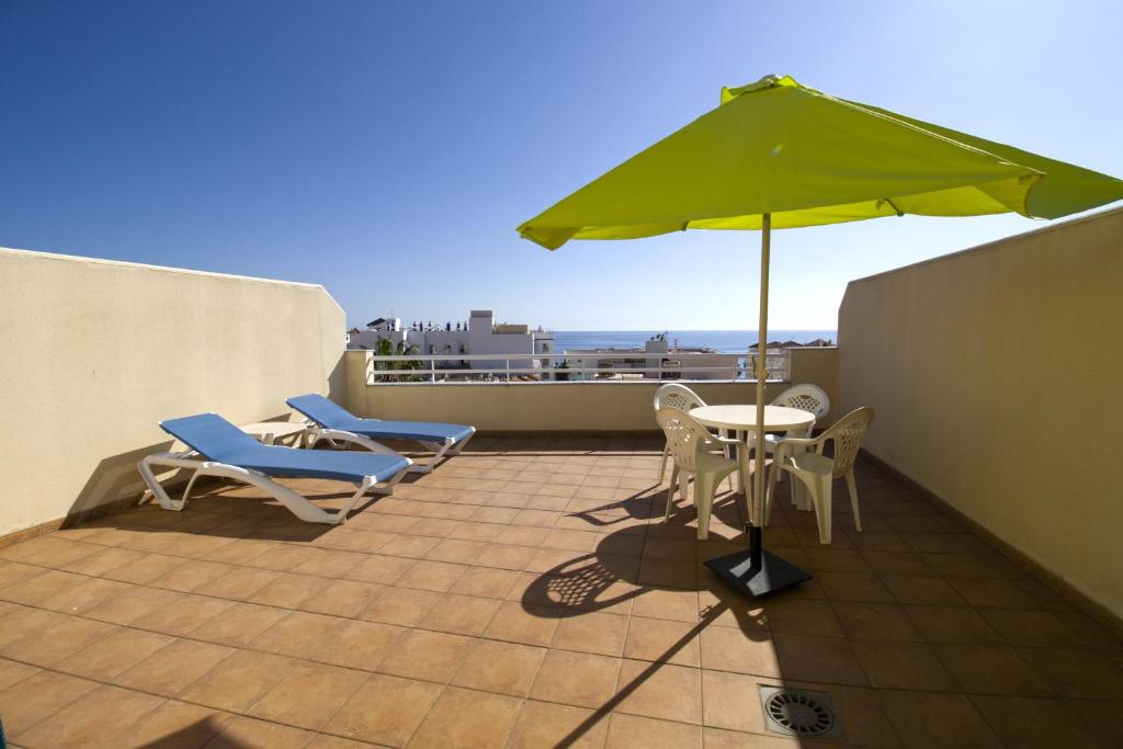 内尔哈菲尔柯马旅游公寓的庭院配有桌椅和遮阳伞。