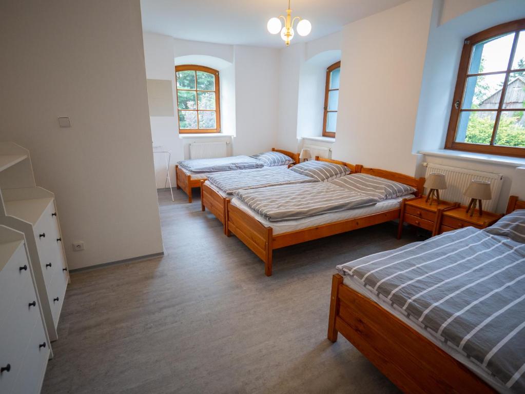 利贝雷茨Rodinná chalupa Ostašovka Liberec的带三张床和两扇窗户的房间
