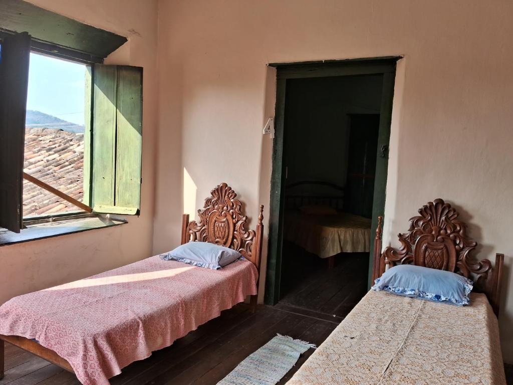 戈亚斯Casa por temporada的两张床位于带窗户的房间内