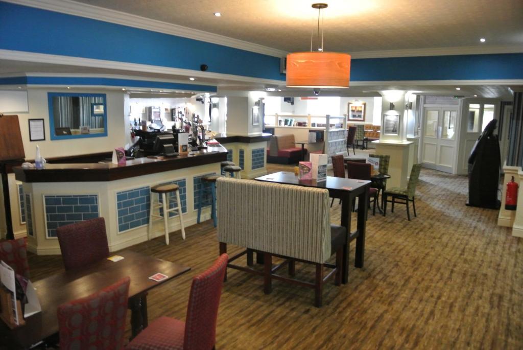 Immingham佩尔汉姆酒店的餐厅设有酒吧和桌椅