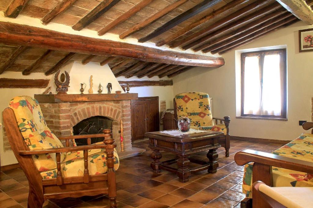 蒙特普齐亚诺拉特拉莎迪蒙泰普尔恰诺酒店的客厅配有椅子和壁炉