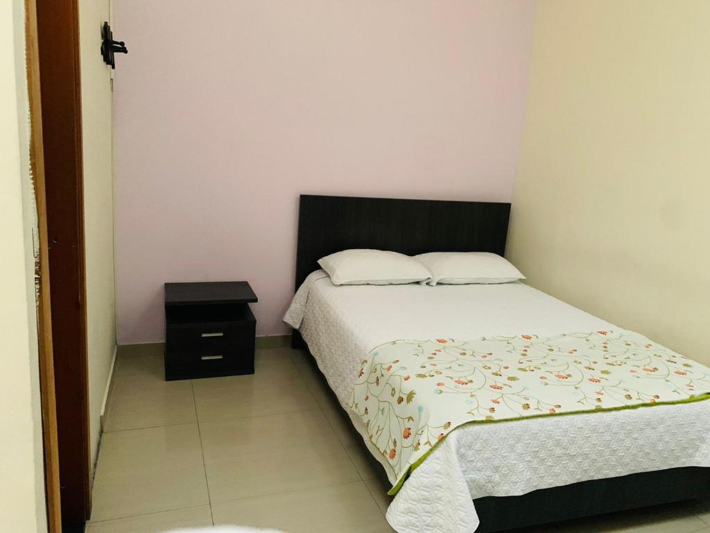 马尼萨莱斯Hostal Zaguán Caldense的一间小卧室,配有床和床头柜