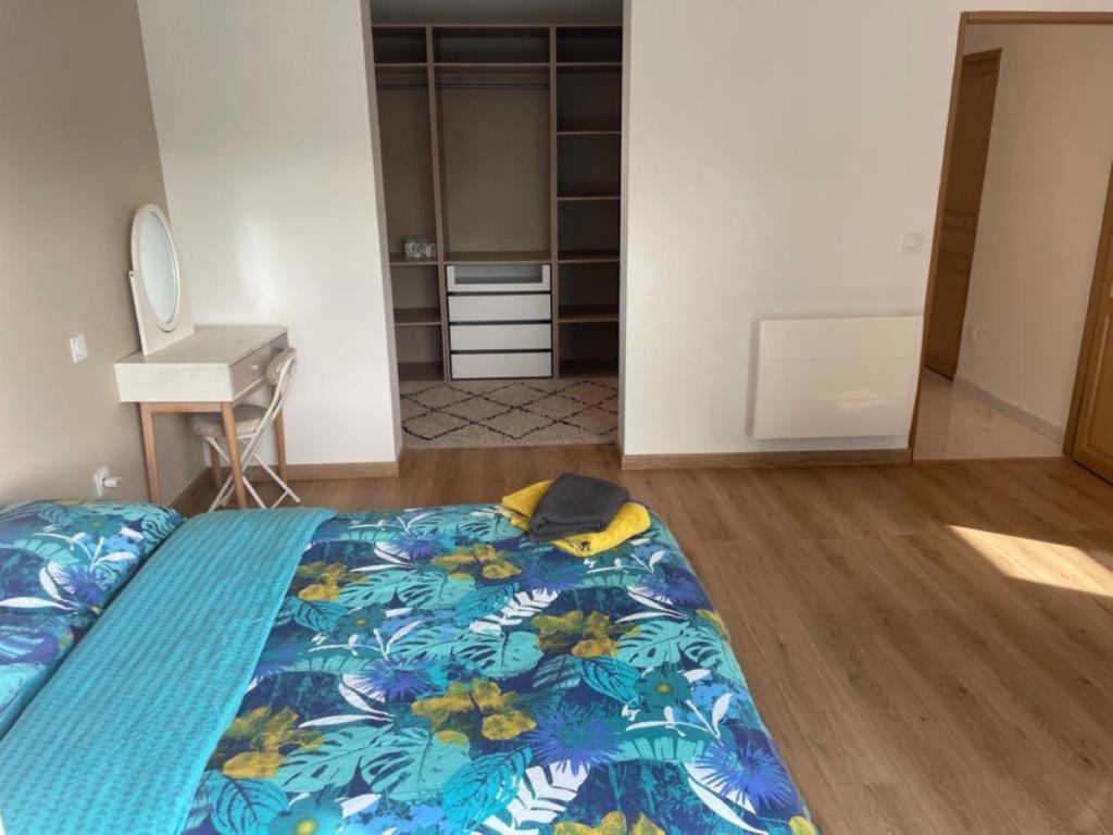 圣热讷维耶夫代布瓦VILLA LENA的一间卧室配有一张带蓝色棉被的床