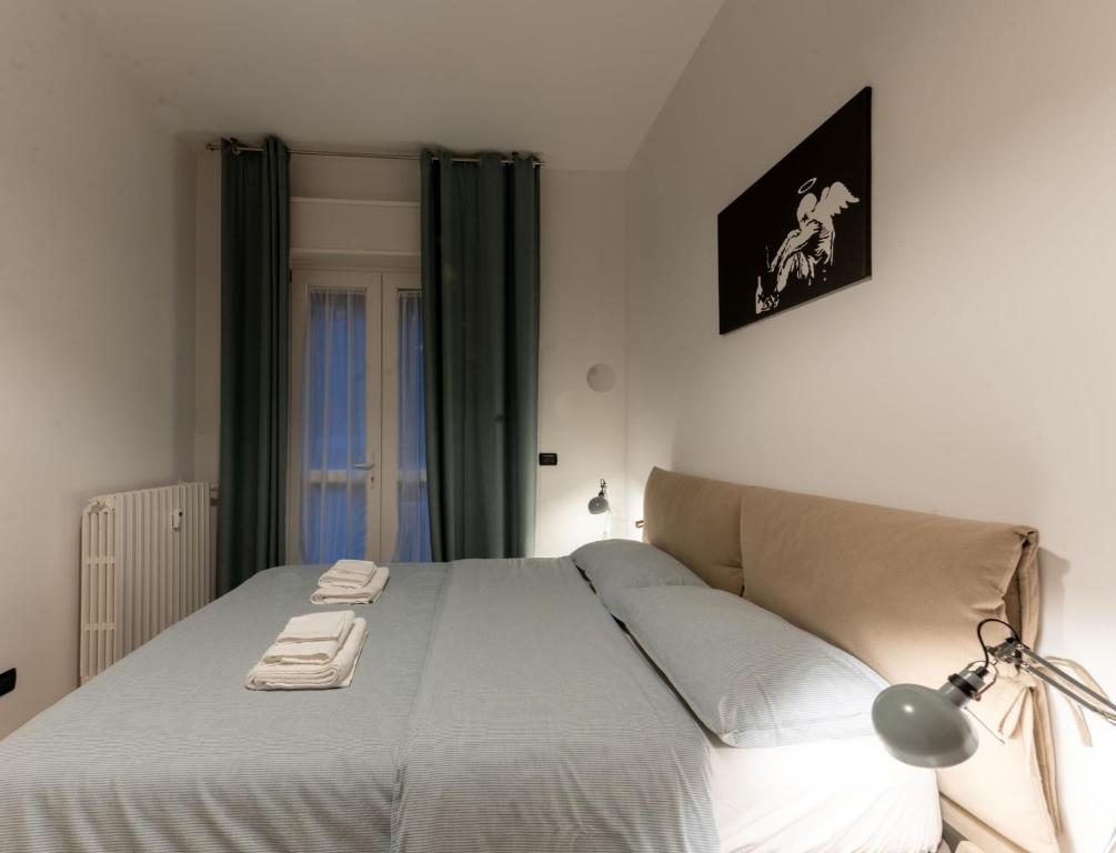 布雷西亚Holiday Apartment - Brescia centro - PARCHEGGIO PRIVATO的一间卧室配有一张床,上面有灯