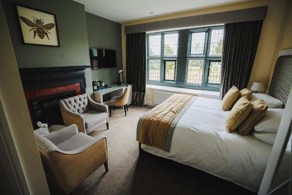 康威Caer Rhun Hall Hotel的一间卧室配有一张床、一张桌子和一把椅子
